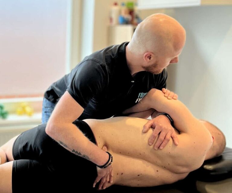 Man met chronische rugklachten wordt behandeld door de fysiotherapeut.
