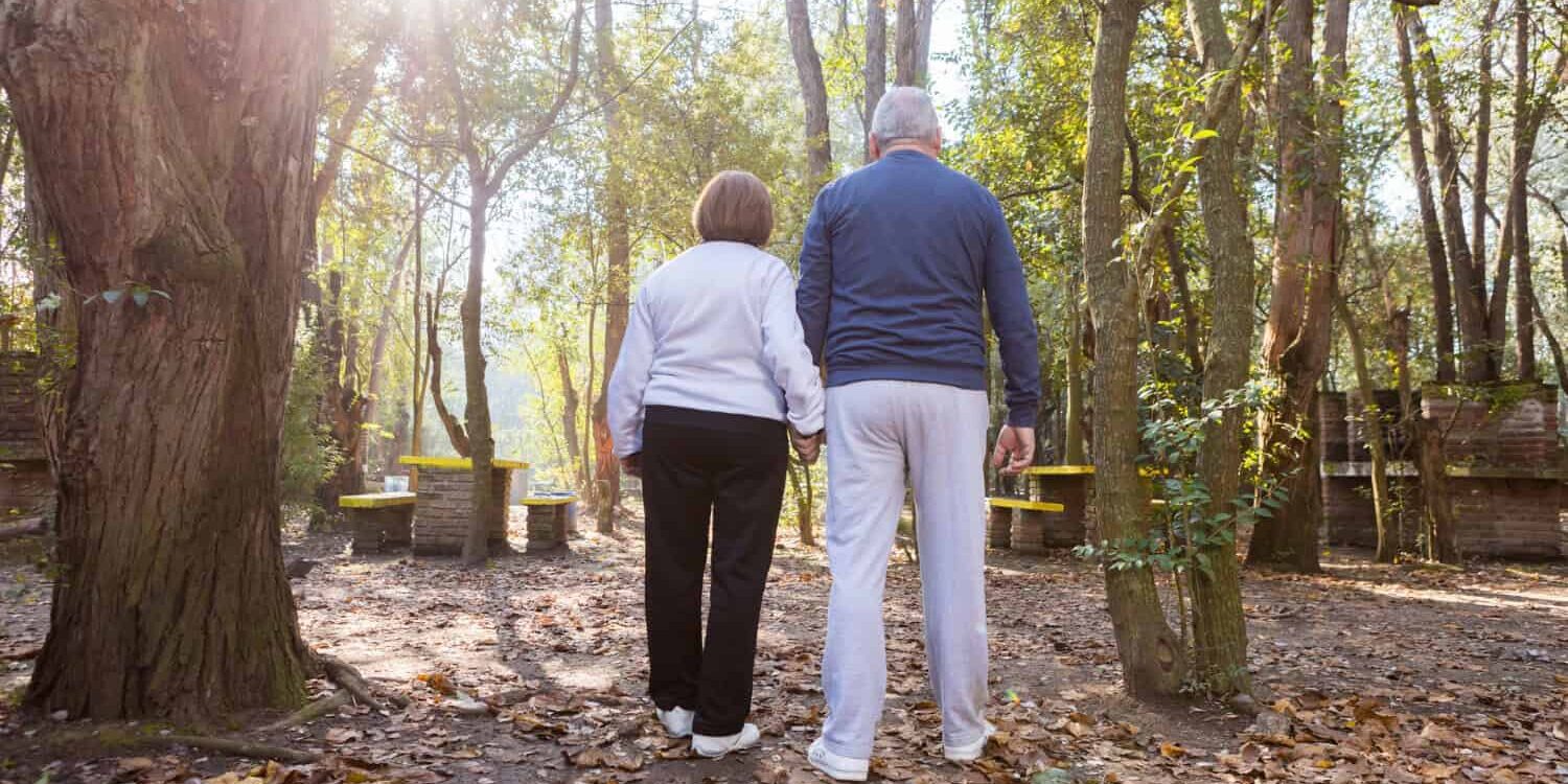 2 older people walk hand in hand to reduce fall risks in older people