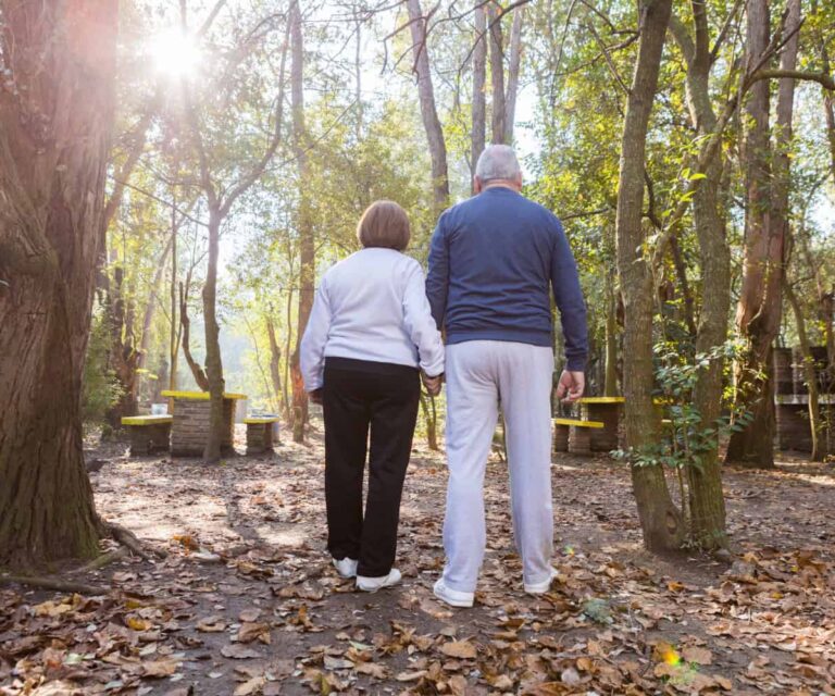 2 older people walk hand in hand to reduce fall risks in older people